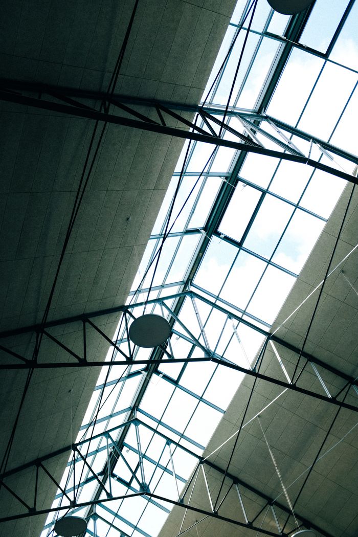 Capturing the contemporary architectural ceiling design with glass panels and metal framework.